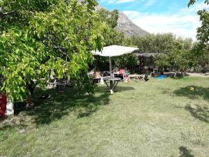 a picnic table with an umbrella in the grass at Agro Camping Los Costeños in Choapa