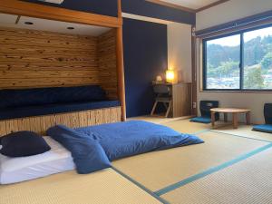 a bedroom with a large bed and a window at Next Chapter - Guesthouse - Kito in Uinouchi