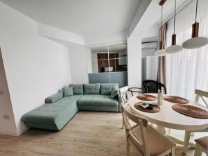 a living room with a green couch and a table at Amira Residence in Eforie Nord