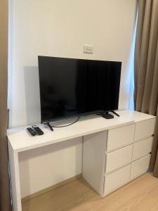 a flat screen tv sitting on top of a white desk at 20 Tree Ville in Ban Ko