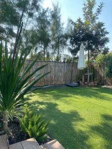 a backyard with a fence and an umbrella at 20 Tree Ville in Ban Ko