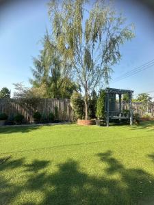 a yard with a tree and a gazebo at 20 Tree Ville in Ban Ko