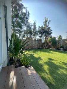 a yard with a wooden deck and a lawn with a fence at 20 Tree Ville in Ban Ko +1 photo