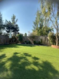 a yard with a fence and a lawn with an umbrella at 20 Tree Ville in Ban Ko