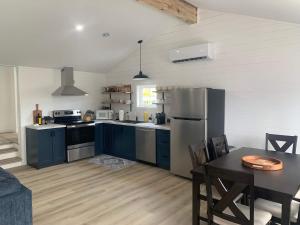 a large kitchen with blue cabinets and a table at Spiller's Cottage in Twillingate
