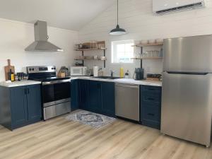 a kitchen with blue cabinets and stainless steel appliances at Spiller's Cottage in Twillingate