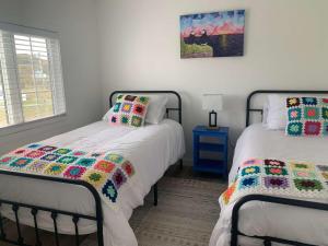 a bedroom with two beds with colorful quilts at Spiller's Cottage in Twillingate