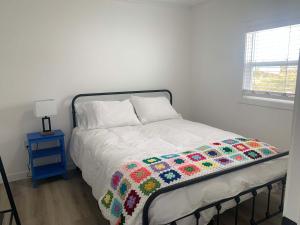 a bedroom with a bed with a colorful blanket on it at Spiller's Cottage in Twillingate