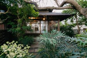 a house with a garden with plants in front of it at Minato-no Akari in Hayama