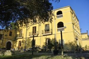 un bâtiment jaune avec des balcons sur son côté dans l'établissement Maset del Garraf, à Olesa de Bonesvalls