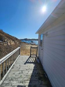 a wooden walkway leading to a building with a door at Salty B'y Cottage in Twillingate
