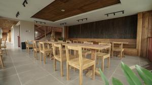 a dining room with wooden tables and chairs at Uma Tilu By Seken Living in Yogyakarta