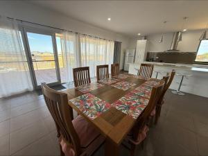 a dining room table with chairs and a kitchen at Karma on Compass in Edithburgh