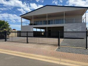 a building with a fence in front of it at Karma on Compass in Edithburgh