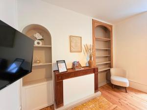 a living room with a tv and a shelf at La Parenthèse à Foix in Foix