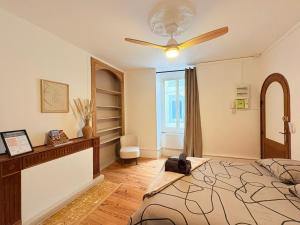 a bedroom with a bed and a ceiling fan at La Parenthèse à Foix in Foix