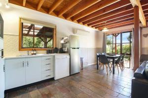 a kitchen with a refrigerator and a table with chairs at The Nest Rustic Lodge-Style Hideaway in Beechworth
