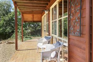 a porch with wicker chairs on a house at The Nest Rustic Lodge-Style Hideaway in Beechworth