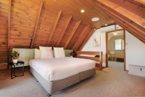 a bedroom with a large bed in a wooden ceiling at The Nest Rustic Lodge-Style Hideaway in Beechworth