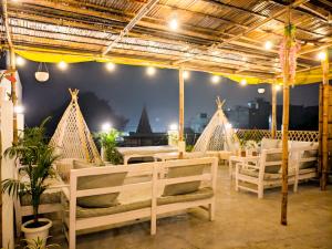 a restaurant with chairs and tables and a view of the city at SAIR Hostel, Varanasi - 100m from Assi Ghat in Varanasi