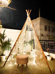 a tent with a stool in a room with plants at SAIR Hostel, Varanasi - 100m from Assi Ghat in Varanasi