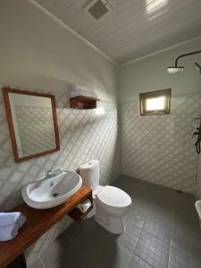 a bathroom with a white toilet and a sink at Toba Crest Vue in Parapat