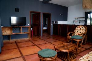 a living room with a tv and chairs and a table at Tiako Beach in Nosy Be