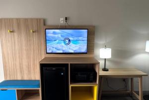 a flat screen tv sitting on top of a entertainment center at Days Inn by Wyndham Ruther Glen Kings Dominion Area in Ruther Glen