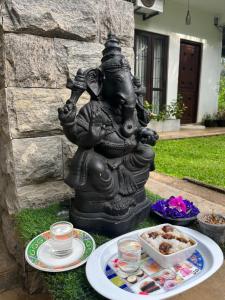 a statue of a deity with a plate of food at Kingdom Gate Hotel in Anuradhapura