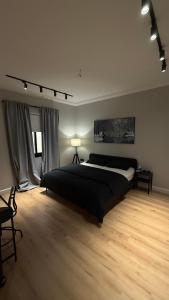 a bedroom with a large bed and a wooden floor at Cozy privet unit شقة وحيدة وهادئة in Riyadh