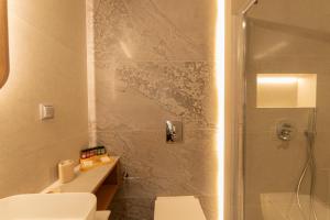 a bathroom with a shower and a toilet and a sink at Aetoma Hotel in Nafplio +39 photos
