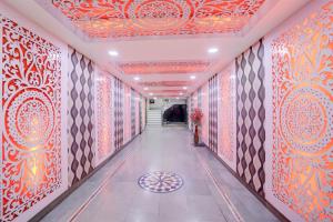 a corridor with red and orange walls and a ceiling at Collection O Ayodhya Ring Road Bhopal in Bhopal