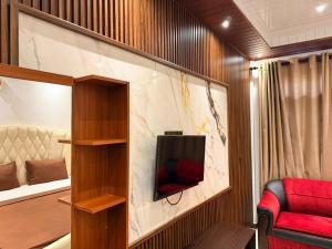 a living room with a tv and a red couch at Millennium Hotel in Jaffna
