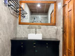 a bathroom with a sink and a mirror at Millennium Hotel in Jaffna