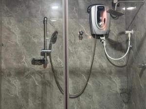 a shower in a bathroom with a handheld shower at Millennium Hotel in Jaffna +4 photos