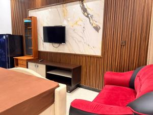 a room with a bed and a red couch and a tv at Millennium Hotel in Jaffna