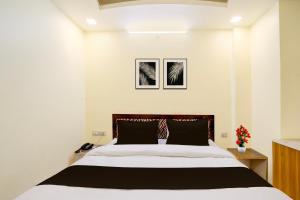a bedroom with a large bed and two pictures on the wall at Collection O Ayodhya Ring Road Bhopal in Bhopal
