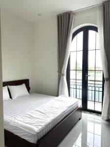 a bedroom with a bed and a large window at Green Hotel in Khánh Dương +5 photos