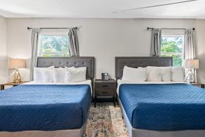 two beds in a hotel room with blue sheets at Baymont by Wyndham Ocala Suites in Ocala