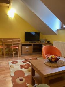 a living room with a tv and a table at Penzión - Tempo in Kremnica