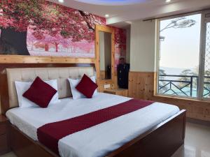 una camera da letto con un grande letto con cuscini rossi di Northern View Howard a Shimla