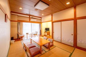 a room with a table and chairs and a dining room at Asoviva Nagano Park in Nagano