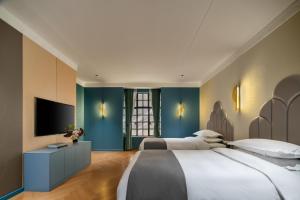a bedroom with two beds and a flat screen tv at ANHE GARDEN HOTEL in Shanghai