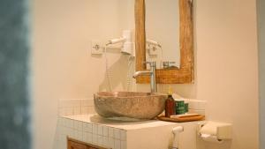 a bathroom with a bowl sink and a faucet at Puri Rinjani Bungalows in Kuta Lombok