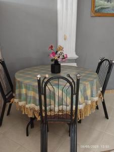 a table with a table cloth and a vase of flowers on it at Penginapan Verlo in Payakumbuh