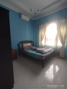 a bedroom with a bed in front of a window at Penginapan Verlo in Payakumbuh