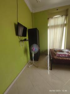 a room with a bedroom with a fan and a television at Penginapan Verlo in Payakumbuh