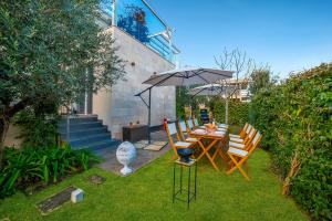 a table and chairs with an umbrella in a yard at 7 Bedroom Luxury Villa - Pool, Garden & Parking - Happy Rentals in Scorrano