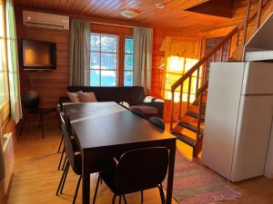 a kitchen and living room with a table and a refrigerator at Arctic Lodge Hetan Kota in Enontekiö
