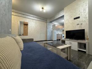 a bedroom with a bed and a tv and a table at Spacious 2 Bedroom Apartment in Iaşi